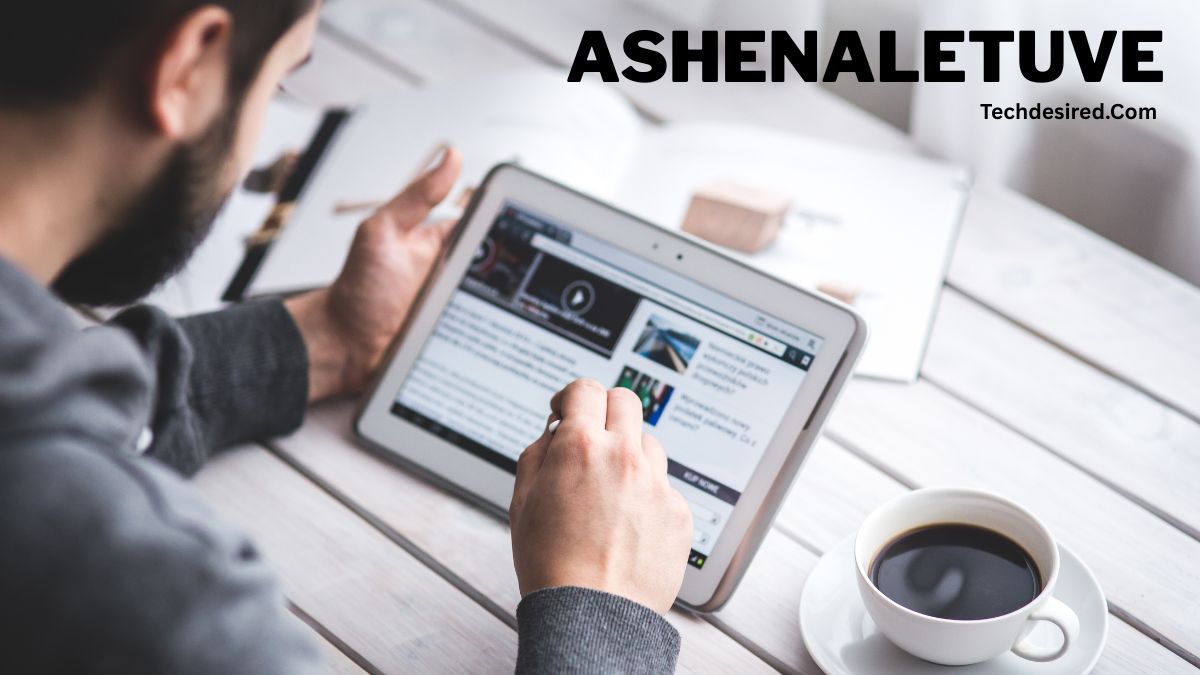 “Person using a tablet at a wooden desk while browsing a technology website, with a cup of coffee beside the device and text reading ‘ASHENALETUVE’ and ‘Techdesired.com’ at the top.”